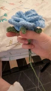 My hand holding the flower head, base and stems - they are not stitched yet.