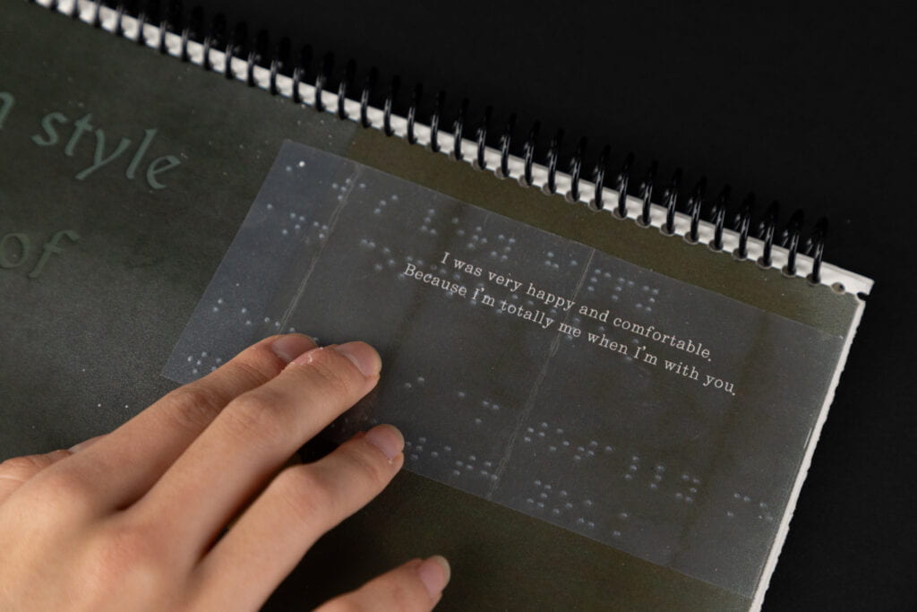 A page of a book with text with clear braille label on top, tactile graphics and qr codes