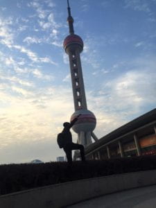 man posing by modern Shanghai tower