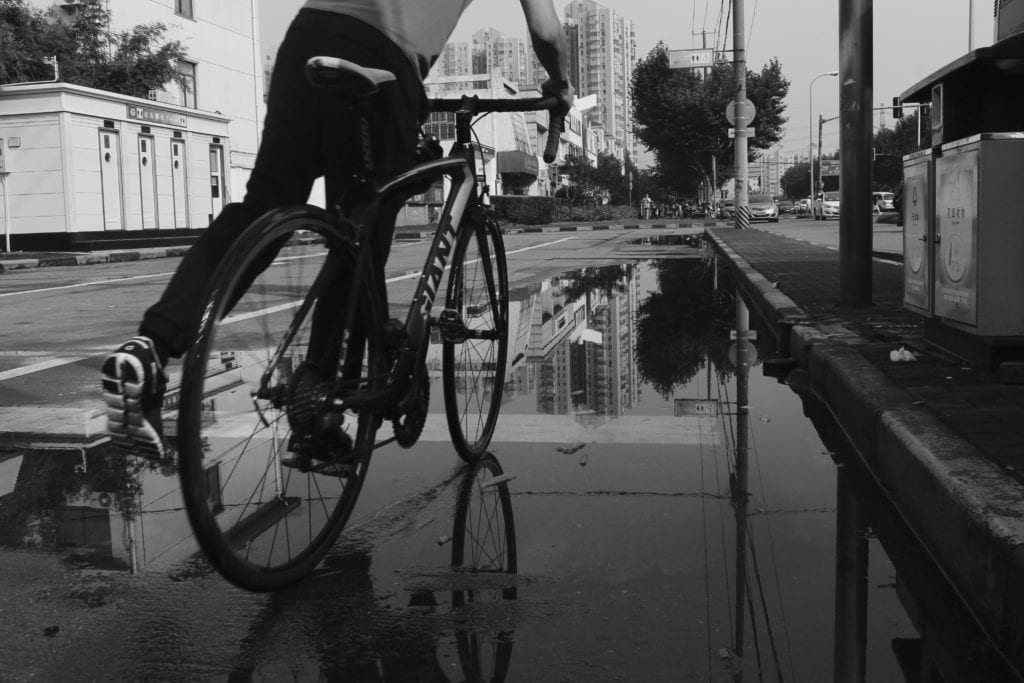 man riding bike on wet pavement