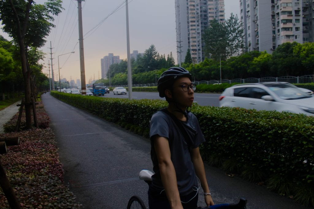 man biking alongside a street