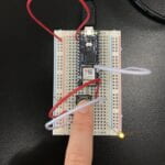 a breadboard with an Arduino Nano connected to 2 pushbuttons and a LED light - one button pressed