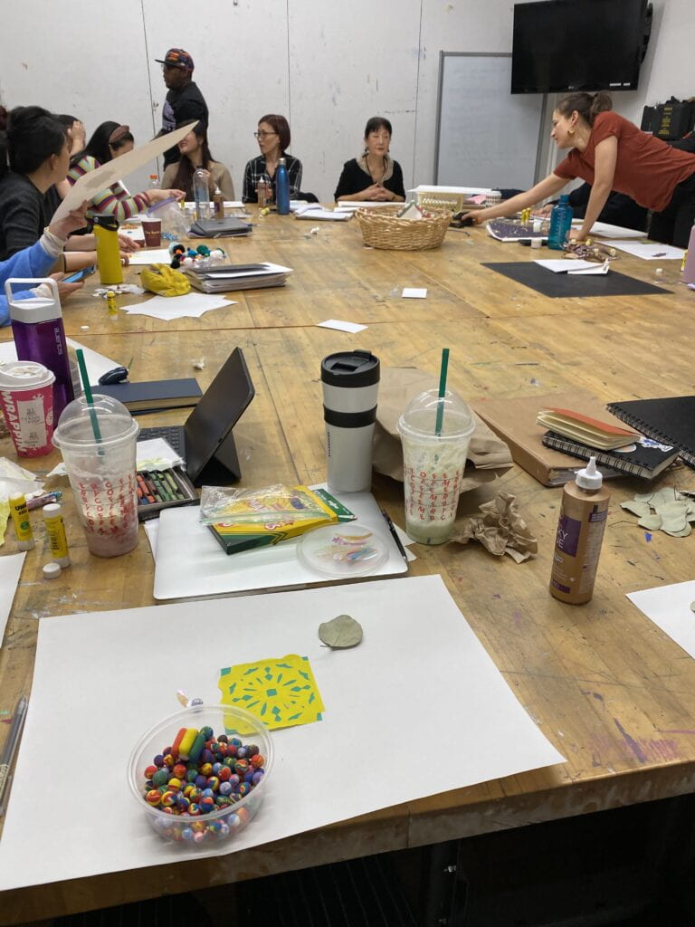 Ikuko sits at a table with students