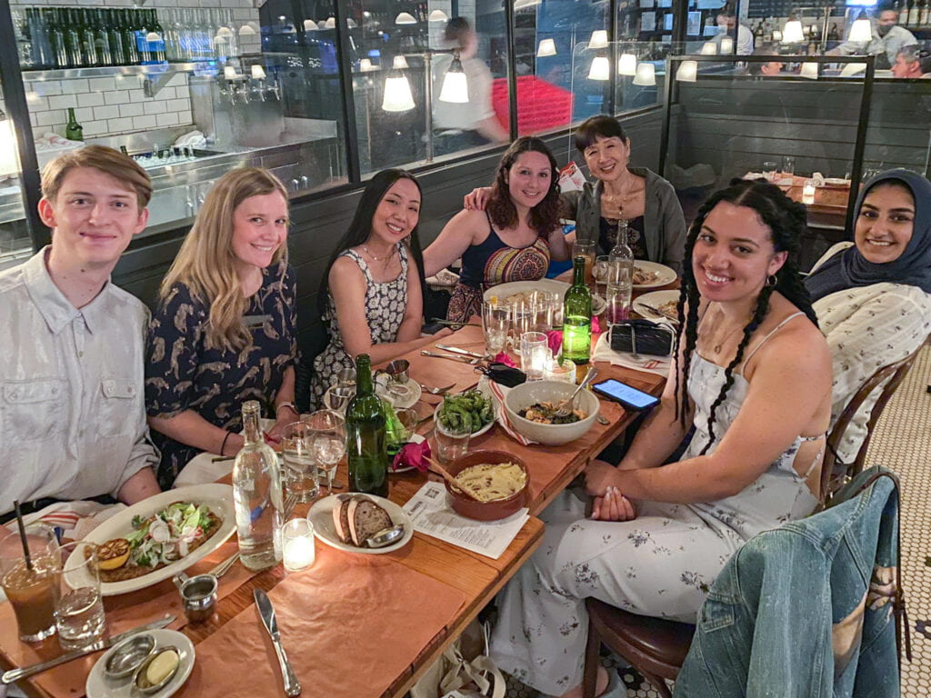 The Art Therapy MA 2021 Cohort pictures at a dinner table with Professor Ikuko Acosta