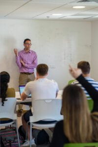 A professor lectures a class of students