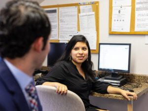 A seated woman turning to look at a colleague