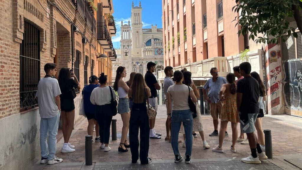 A group of students gathering with a professor on the street in Madrid.