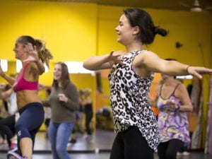 A smiling student dances in a dance class