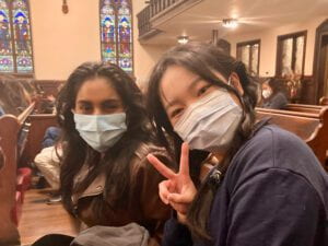 Two masked students pose for the camera in the Church of the Epiphany