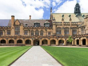 A building in the Victorian Academic Gothic Revival style in front of a green manicured lawn