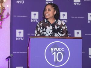 Kari Miller speaking at a podium that says "NYUDC at 10"