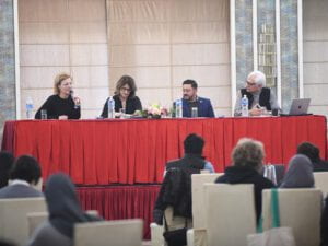 Four people seated at a table on a stage