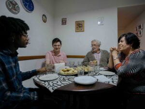 Two students sitting at a table with their host family for dinner