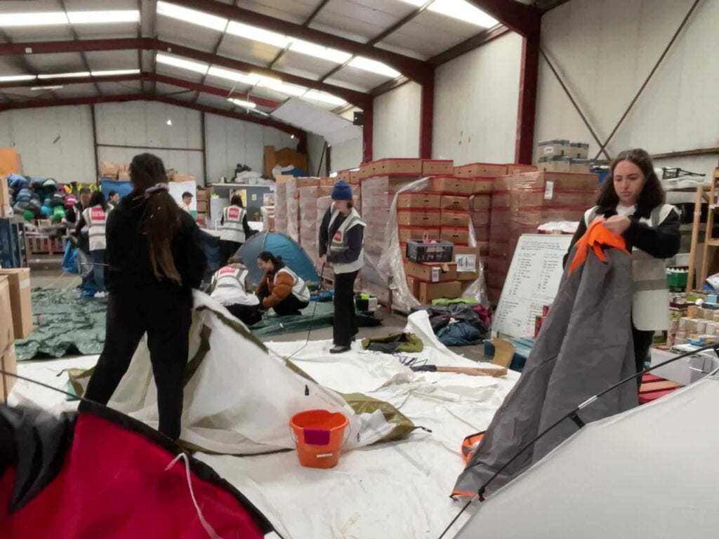 People inspect tarps and tents in a large room