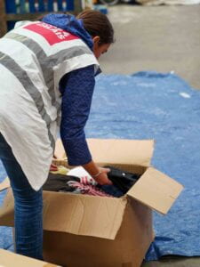 A person leaning over a cardboard box