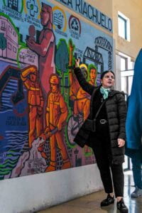 Architect Cecilia Alvis points to a colorful mural