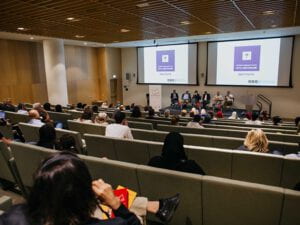 AD Institute event in an auditorium with panelists seated on stage