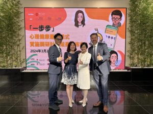 A group of individuals stand in front of a decorative poster.