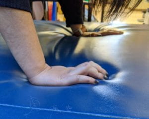 ATTEMPTING A PLANK POSITION, HOWEVER THE FINGERS ARE CURLING IN ON THE MAT