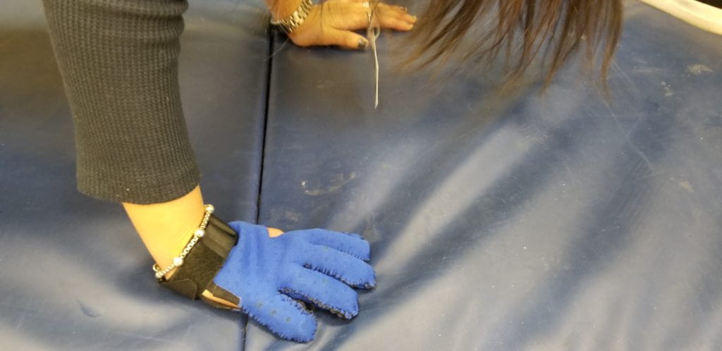 PATIENT IS PRACTING A PLANK WITH THE COMPLETED GLOVE AND IS DEMONSTRATING THAT THE FINGERS ARE SLIPPING DUE TO THE NEOPRENE MATERIAL