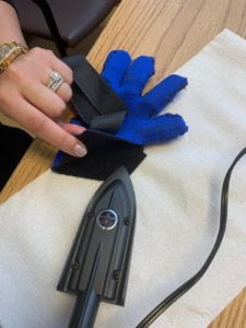 IRON IS USED TO IRON ON SEAM TAPE AROUND THE EDGES OF THE GLOVE TO PREVENT FRAYING