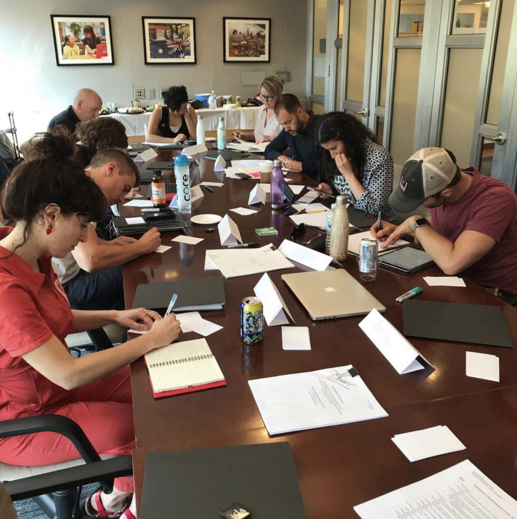 Image of people working around a table.