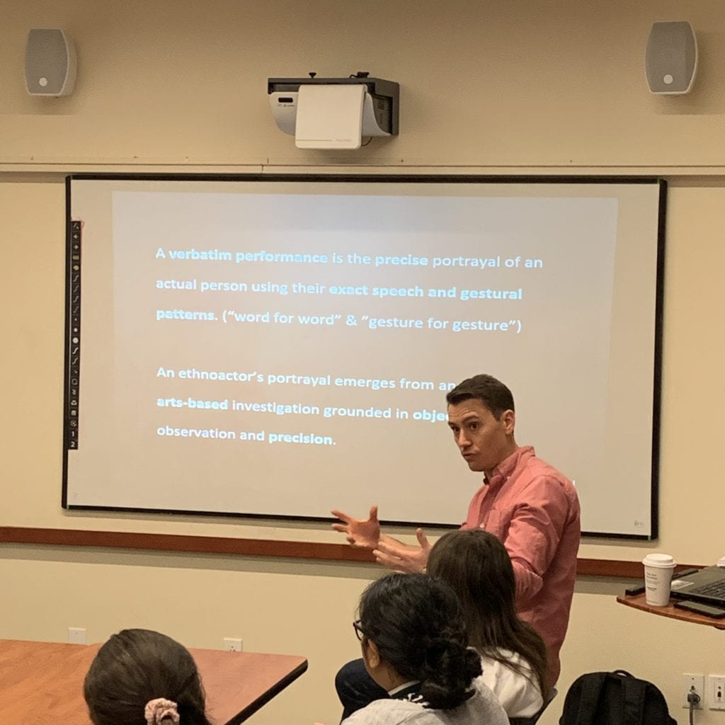 Teacher explaining a concept to students using a projected slide.