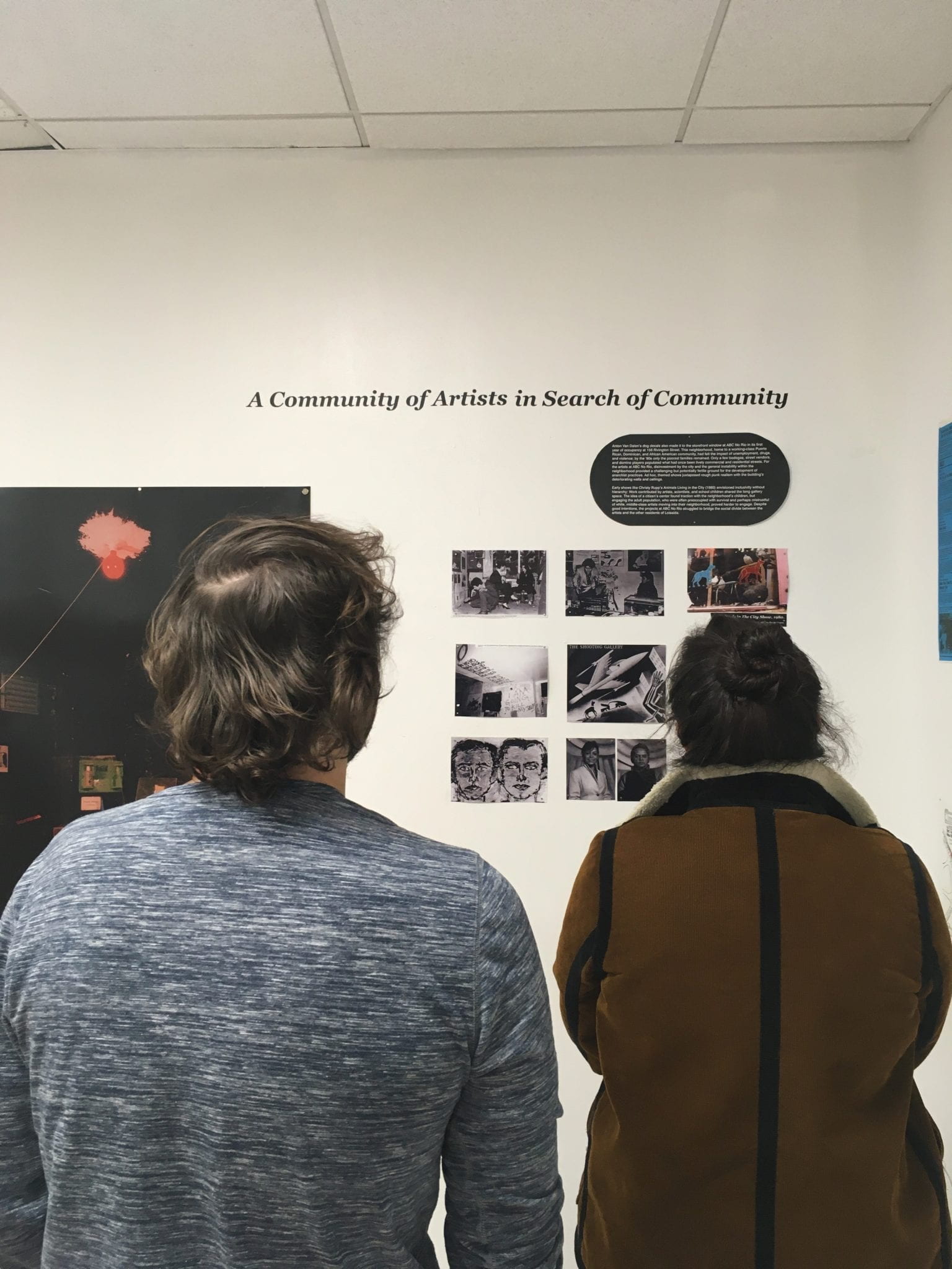 Students reading label text at the exhibition.