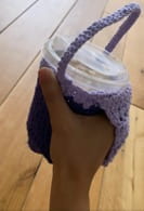 his is a crochet hot/cold drink carrier with a handle on the side and a removable crochet butterfly on the handle to carry hot/cold drinks