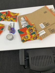 A table with prototyping materials including scissors, cardboard, fabric and duck tape.