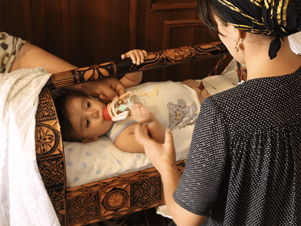 Infant in Tajikistan is in a "gahvora" cradle