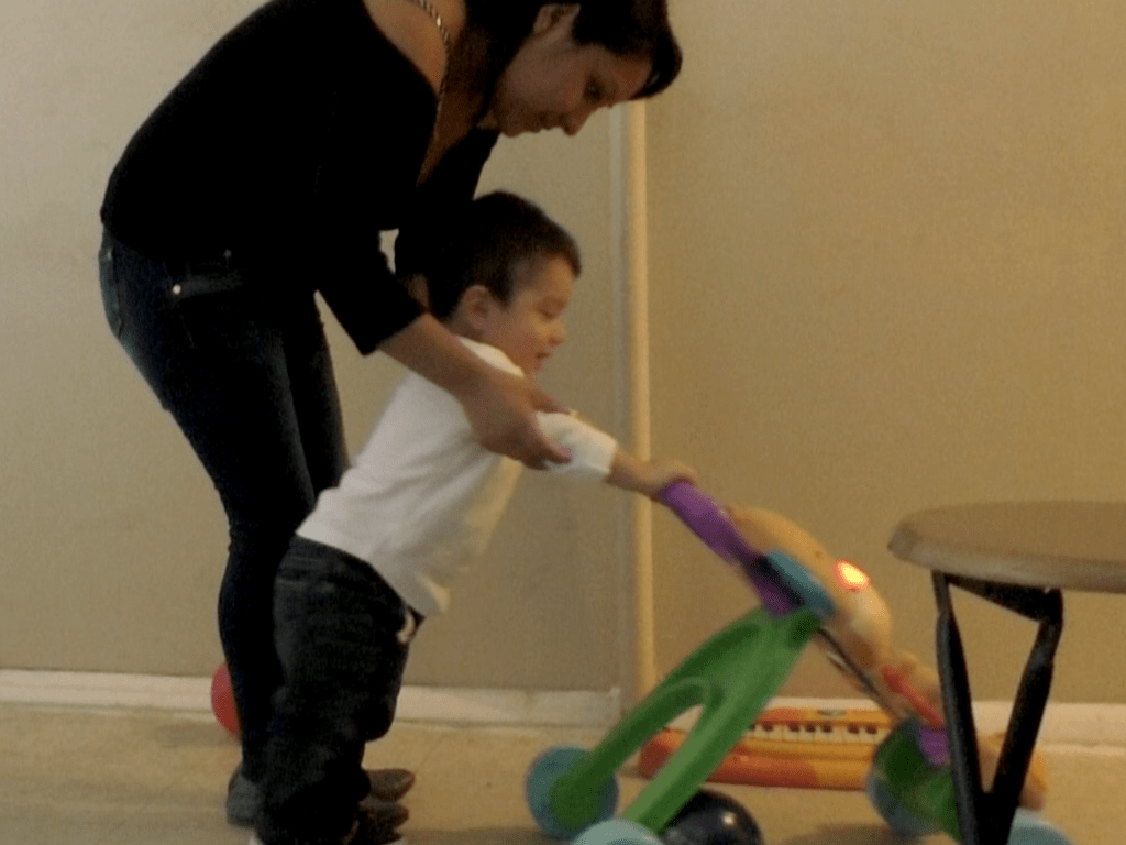 Mother and child are playing with a stroller together