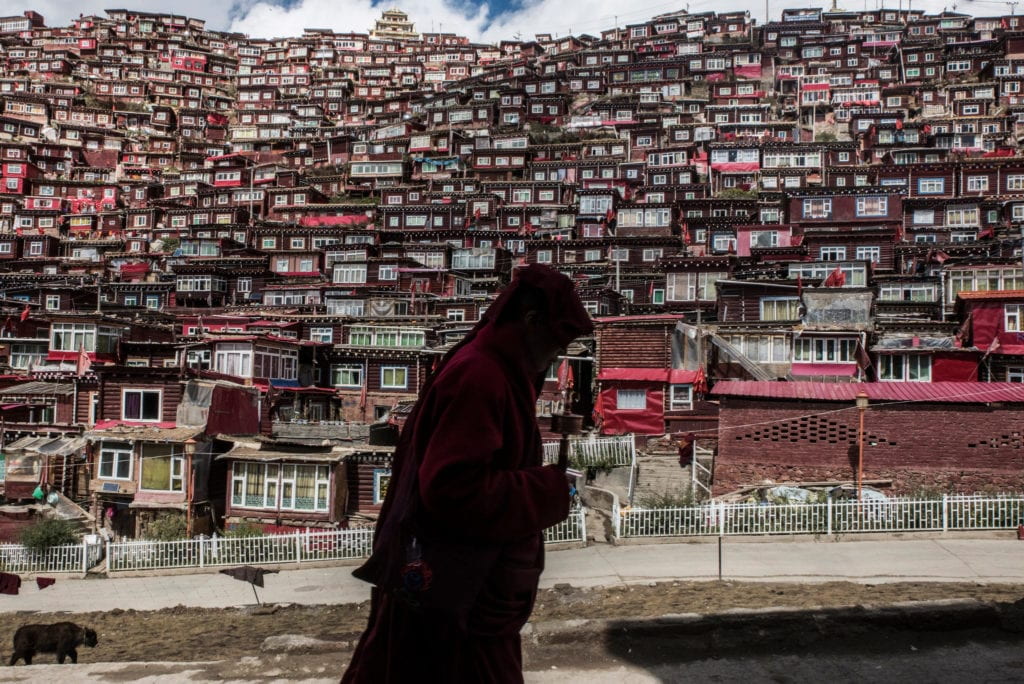 A Buddhist nun with a prayer wheel in Larung Gar, a monastic camp where thousands of nuns and monks live and study, in Sichuan Province, China. Credit Gilles Sabrié for The New York Times 