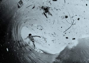 A surfer in plastic filled / debris filled wave