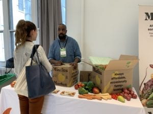 person boxing up vegetables in a box labeled "Misfits Market"