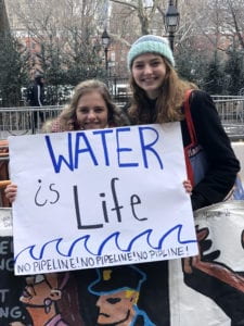 Josi holding protest sign that reads: "Water is life"