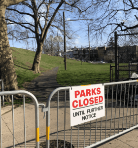 Fence at the entrance to a park with the sign that reads "Parks closed until first notice"