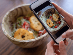 person taking a picture of a bowl of food