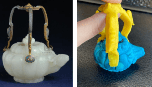 side by side picture of original teapot next to plastic recreation. Original teapot has jade base with ram head at the spout and three thin metal handles. Recreation has blue teapot base with ram head spout and thicker yellow handles. 