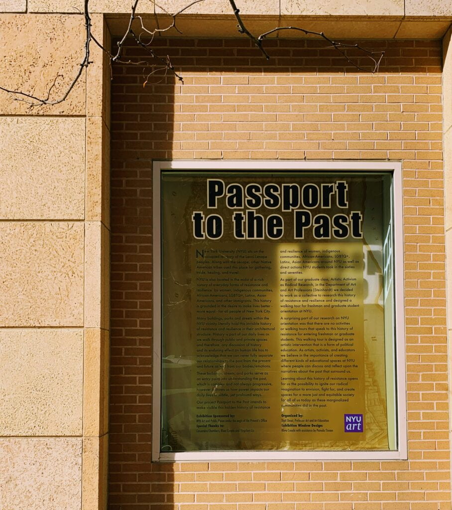 Photograph of glass case on brick wall with text "Passport to the Past" 