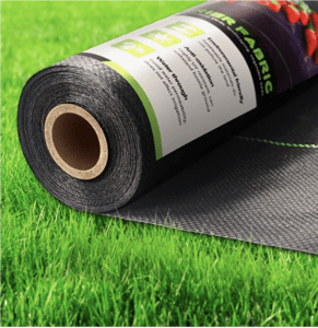 Roll of black, firm, weed barrier landscape on green grass