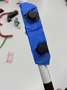 The image shows a frontal view of the Twist plug taped onto the cane with tape