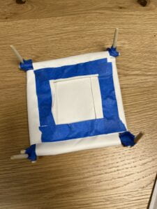 bottom side view of small rectangular cot with blue painter's tape cover the resistor wires