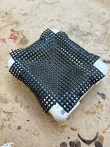 Small trampoline mesh and PVC tube prototype with multiple screws drilled in