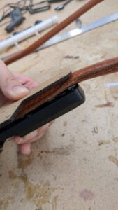 A side view of the same setup as above, with the leg of the harness is visible, sandwiched between the cardboard and magnet.