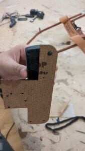 A group member holds up the Fidlock Twist socket with a piece of wood attached by fitting a screw through the wood and into one of the socket's screwholes.