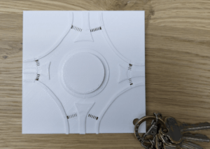 A top view of our final 3D roundabout model, which shows the keyhole and depression in the sidewalk. There is a key at the bottom right near the hole to demonstrate where to attach the keychain.