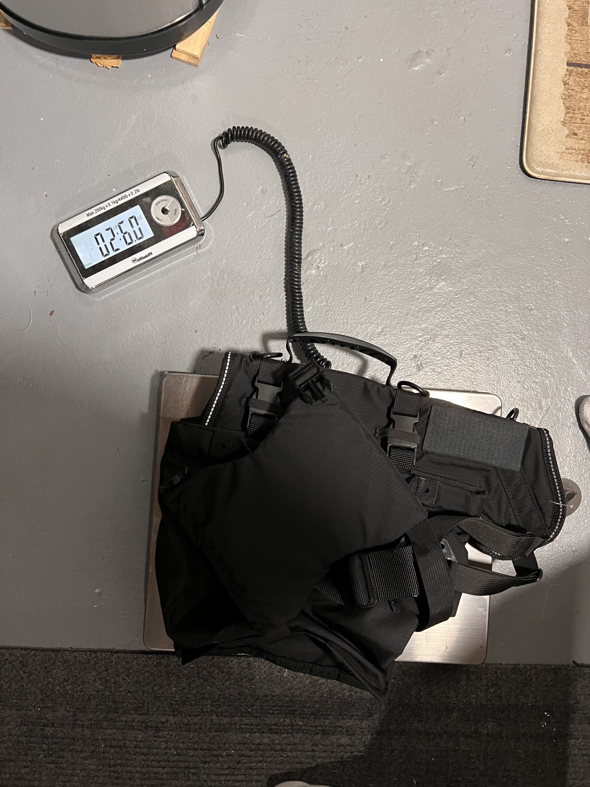 An image of the bag with adaptations being wieghed on a floor scale. 