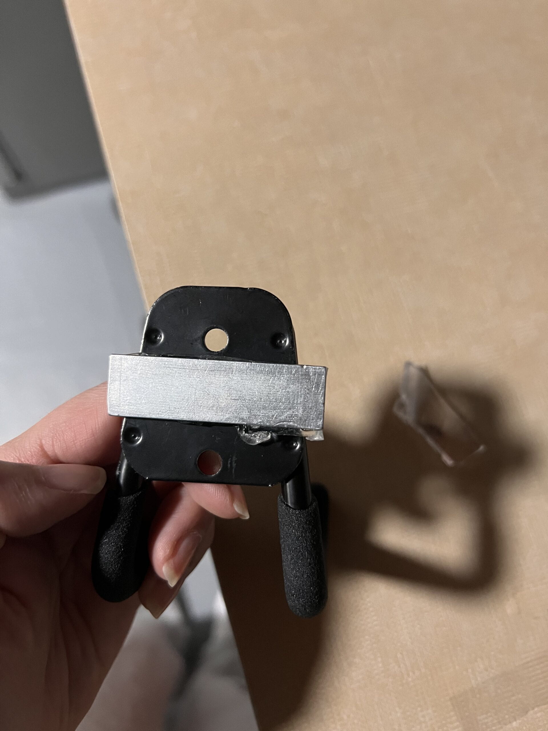 An image of a magnet attached to the back of the hook with double sided tape to ensure stability when testing the mock dispoz-a-scoop attachment to the hook.