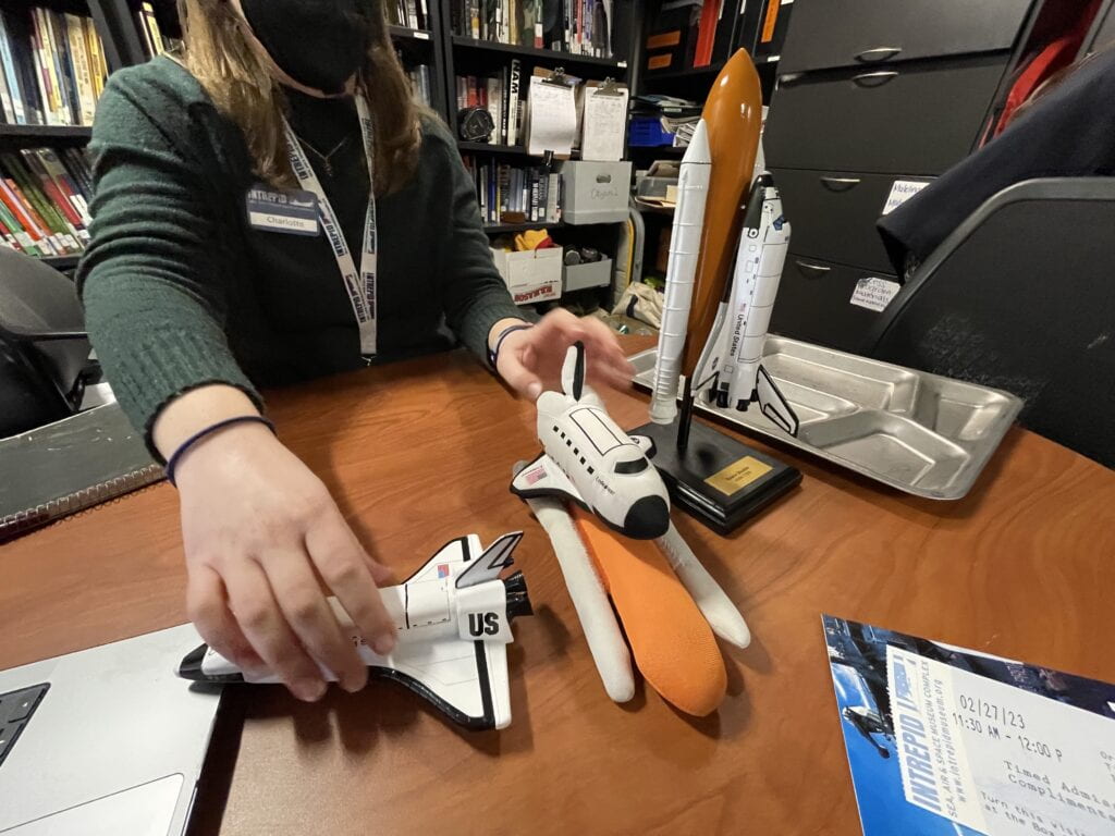 A woman's hands holding three space shuttle models